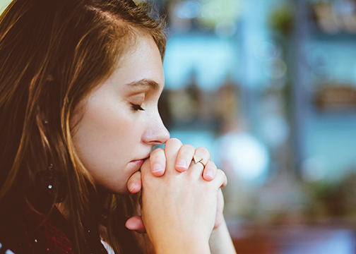 Woman praying with her eyes closed